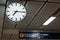 Clock in airport with signboard