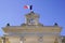 Clock on city hall in France town with french flag in wind