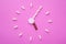 Clock created from white pills and brown tablets on pink background. Right time for using medicines