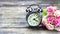 Clock gold retro and flowers on a wooden table.