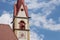 The clock painted outside the bell tower of the church in Selva di Val Gardena into the Dolomites area