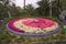 Clock in a park surrounded by flowers that draw a concentric spiral