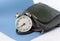 Clock with a school satchel on a blue background, close-up, side view-the concept of starting school classes in schools