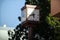 Clock situated on a city street with trees in the background