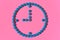 A clock symbol made from tablets on a pink background. Concept of women`s health, female contraception, pregnancy.