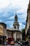 Clock tower of St Alfege Parish church, Royal Borough of Greenwich in London behind a common houses.