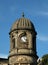 Clock tower with stone cupola against a blue sky on the former sowerby bridge town hall