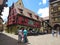 Clock tower and traditional Houses with colorful facades and sloping roofs in Riquewihr, France.