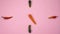 Clock from vegetables moving arrows from carrots on a pink concrete background stop motion