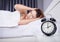 Clock with woman sleepless on bed