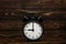 Clock on a wooden background. The clock shows the time of nine o`clock in the afternoon. The clock shows the time of nine o`cloc