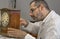 Clockmaker repairs clocks and watches  in his laboratory