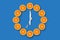 Clocks made of half cut tangerines with arrows made of fork and knife that shows 7 o`clock on a blue background.