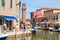 Clocktower, colorful houses and canal on the island of Murano near Venice