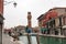 Clocktower, colorful houses and canal on the island of Murano near Venice