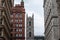 Clocktower of Notre Dame Basilica in the Old Montreal, surrounded by the tower of old stone and brick buildings.