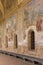 Cloister Santa Chiara, view of corridor under arcades and decorated colorful frescoes, Naples, Italy