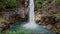 Close aerial view waterfall lake with tree stones on foreground