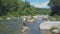 Close Backside View Man with Electric Rod Steps in River Water