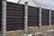 Close board fence erected around a garden for privacy with wooden fencing panels, concrete posts and kickboards for added