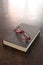 Close book with empty cover and a pair of glasses on a wooden table