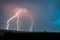 Close branched lightning bolts strike down to earth at dusk