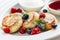 Close cheese pancakes, syrniki, curd fritters with fresh raspberries on white plate background