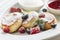 Close cheese pancakes, syrniki, curd fritters with fresh raspberries on white plate background. Decorated with powdered