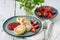 Close cheese pancakes, syrniki, curd fritters with fresh strawberries on plate background