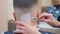 Close-cropped males nape with shaving mousse, close shot. Stylist shaving clients nape with open razor. Man in