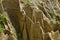 At close of the famous Stobâ€™s Pyramids with unusual shape red and yellow rock formations, green bushes and trees around