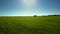 Close flight over green field and lorry on skyline