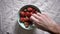 Close footage of different hands taking strawberries from bowl