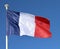 Close of of the French Flag flying against a clear blue sky