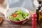 Close of male hand holding a bowl with salad