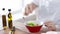 Close of male hands mixing salad in a bowl