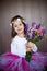 Close ortrait of a little sweet smiling girl holding bouquet of