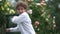 Close outdoor portrait curly teenager boy dancing in summer rain. Happy childhood