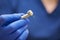 A close photo of a hand of a dentist who holds a dental diamond drill