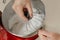 A close photo of the hand of a woman who is mixing meringue in a bowl