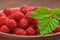 Close-photographed berries of a raspberry in a ceramic dish, a healthy diet