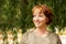 Close portrait of a beautiful middle-aged woman looking away with a background of green foliage