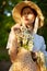 close portrait of a beautiful woman in a wicker hat and with a plaid in her hands holding a basket of daisies