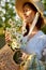 close portrait of a beautiful woman in a wicker hat and with a plaid in her hands holding a basket of daisies