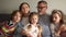 Close portrait of a big happy family. Grandparents are sitting on the couch hugging their three grandchildren. Family