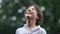 Close portrait curly boy in white shirt, happy childhood. Schoolboy has fun in the warm summer rain. Close portrait