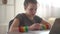 Close portrait of a curly-haired girl has online lessons using a laptop and headphones. Schoolgirl records a lecture and