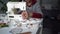 Close portrait of an elderly seamstress. A pensioner sews curtains on a sewing machine at home