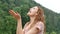 Close portrait. A happy curly girl in the mountains enjoys summer rain without an umbrella. The girl is happy and laughs