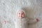 Close portrait of a little baby boy in white knitted onesie and